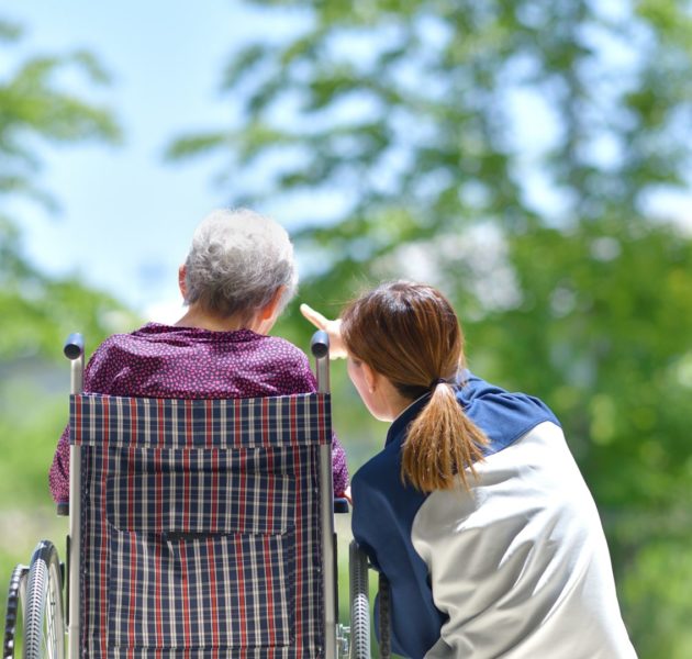 Elderly lady with carer outside
