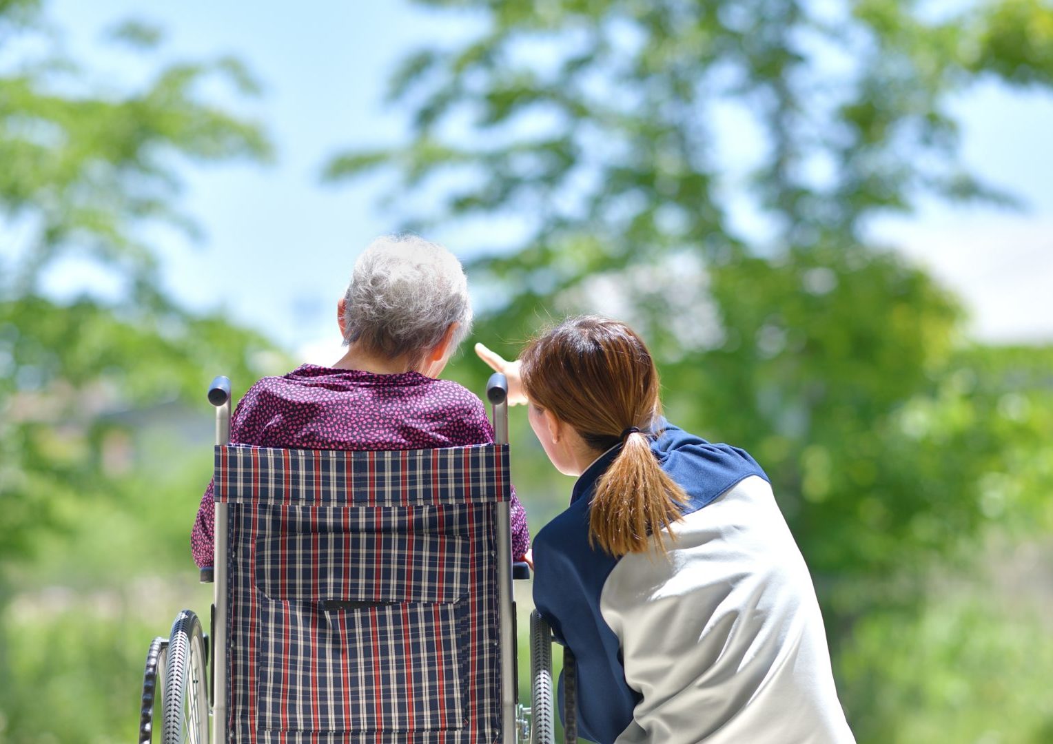 Elderly lady with carer outside
