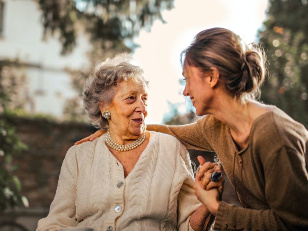 Elderly lady with younger woman in garden