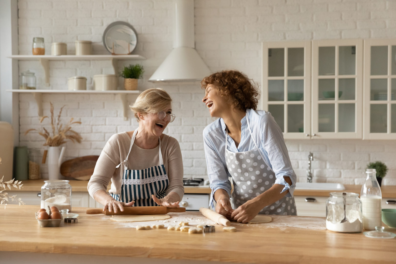 Elderly lady enjoy rolling dough with adult daughter having fun