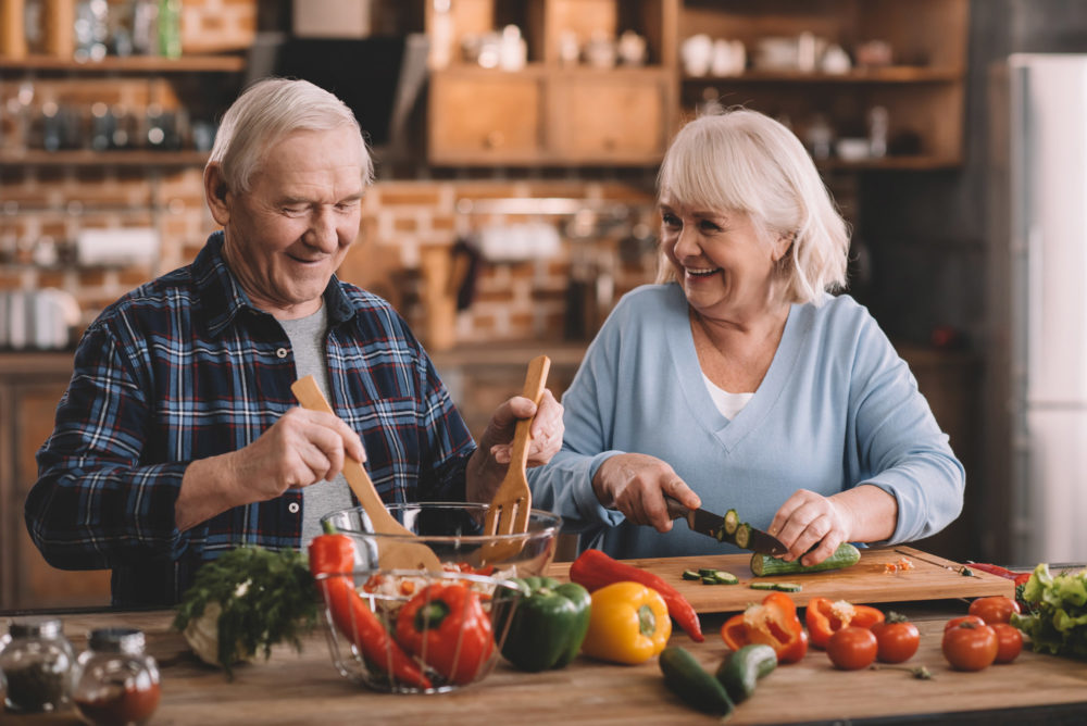 elderly-couple-cooking-food-together